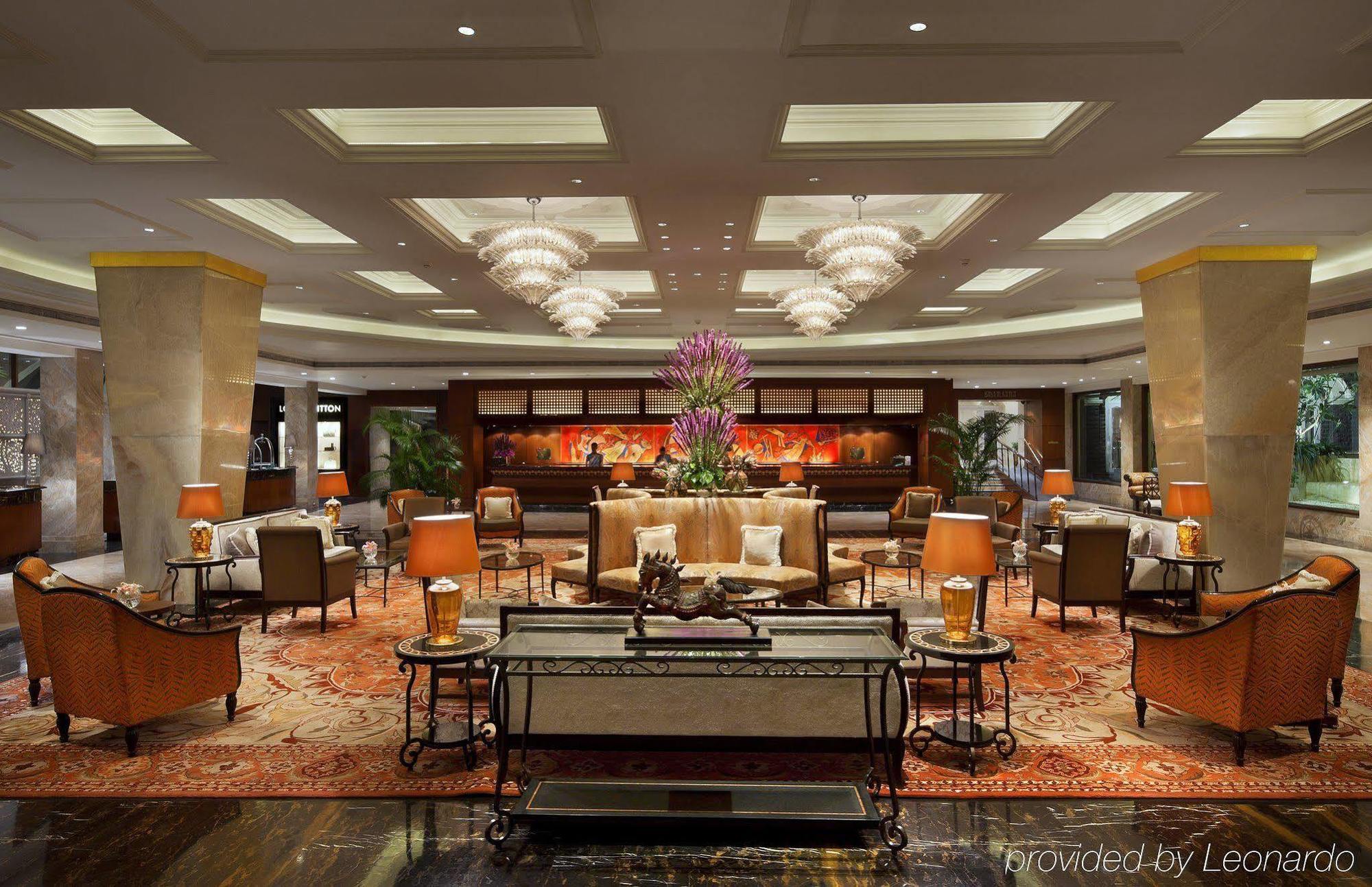 The Taj Mahal Tower, Mumbai Hotel Buitenkant foto The photo shows an elegant hotel lobby. It features a spacious area with plush seating, including stylish armchairs and sofas arranged around coffee tables. Central to the space is a large flower arrangement, adding a touch of color and sophisticatio