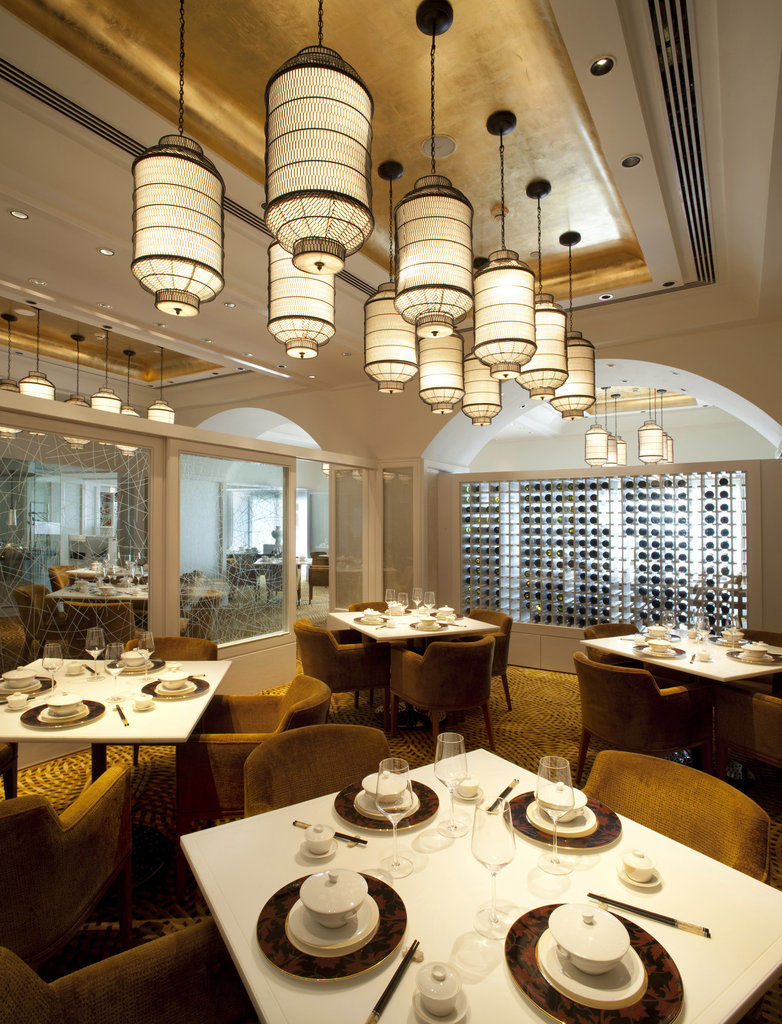 The Taj Mahal Tower, Mumbai Hotel Buitenkant foto The photo depicts an elegant restaurant interior. It features a sophisticated design with multiple hanging light fixtures that have a distinct, stylish appearance. The tables are round and set for dining, with neatly arranged plates and utensils. The