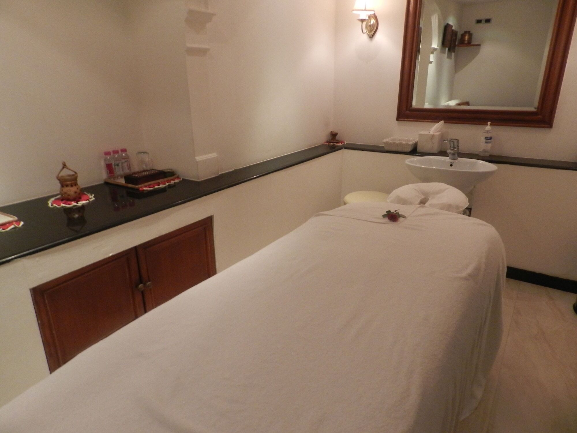 The Taj Mahal Tower, Mumbai Hotel Buitenkant foto The photo shows a serene spa room designed for relaxation and treatments. In the center, there is a massage table covered with a white sheet. There is a small decorative item, possibly a flower, placed on the table. Alongside, a dark countertop displ